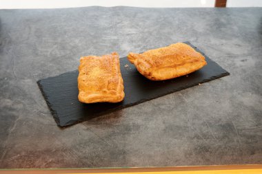 Siyah tabakta iki hamur işi. Biri solda ve diğeri sağda.