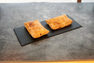 Siyah tabakta iki hamur işi. Tabak tezgahın üzerinde. Tezgah betondan yapılmış.