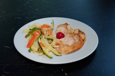 Bir tabak et ve sebzeyle birlikte bir tabak yemek. Et küçük parçalara ayrılır ve sebzeler ince şeritler halinde kesilir.