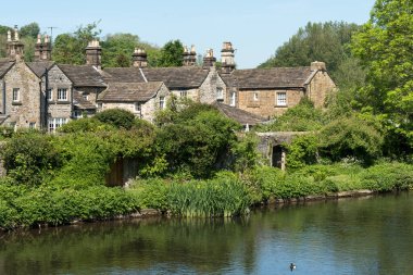 BAKEwell, DERBYSHIRE, İngiltere, 19 Mayıs. 19 Mayıs 2024 'te Bakewell, Derbyshire' da Wye nehri kenarındaki evler