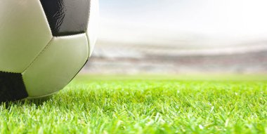 Futbol stadyumundaki çimlerin üzerindeki futbol topunun ayrıntıları. Ön görünüm.