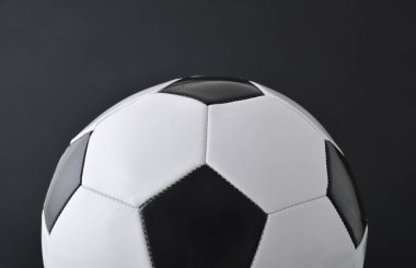 Siyah arka planda izole edilmiş yarı klasik siyah beyaz deri futbol topunun detaylı görüntüsü. Ön görünüm.