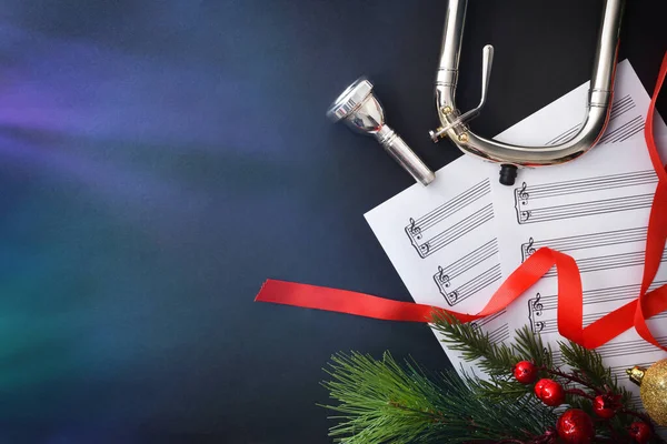 Trombone christmas music concert concept with christmas decoration sheet music and mouthpiece. Top view.