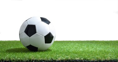 Yapay çim ve beyaz izole arka planda klasik futbol topu. Yatay bileşim.