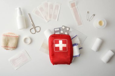 First aid travel bag on white table full of tools and equipment for cures. Horizontal composition. Top view. 