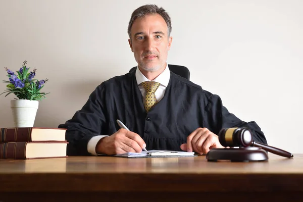 彼のオフィスで働いている裁判官は 木製のテーブルの上に文書を見直す 正面図 — ストック写真