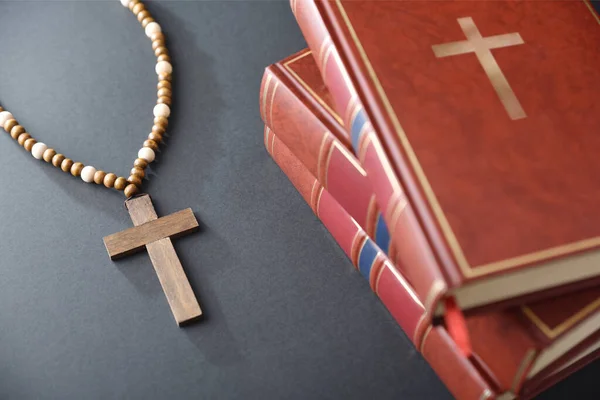 Egy Halom Vallásos Könyv Kereszt Fából Készült Gyöngyökkel Fekete Asztalon — Stock Fotó