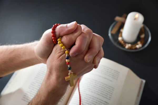 Кристиан Молится Четками Руках Скрещенными Пальцами Библией Свечой Столе Заднем — стоковое фото