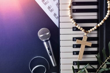 Paskalya Hıristiyan dini konser konsepti. Siyah arka planda piyano ve mikrofon var. Kırmızı ışık altında. Üst görünüm.