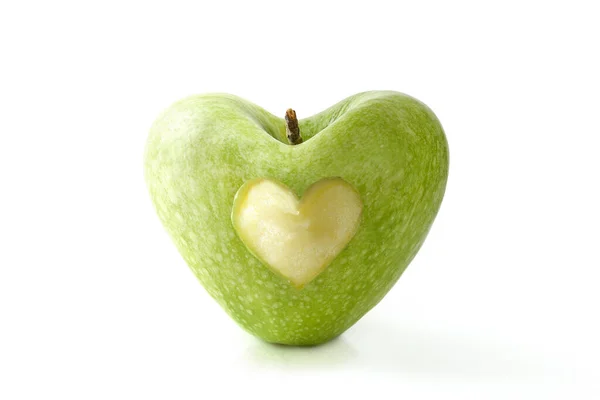 中心部で食べるハート型の半分が白いテーブルと白い隔離された背景に反映された緑色のリンゴ 健康の概念 正面図 — ストック写真