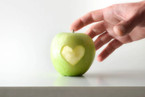 Hand Plocka Äpple Med Hjärta Vitt Bord Och Vit Isolerad — Stockfoto