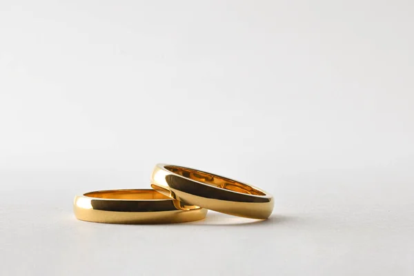 Detail Dvou Zlatých Svatebních Prstenů Ležících Jeden Druhém Bílém Izolovaném — Stock fotografie