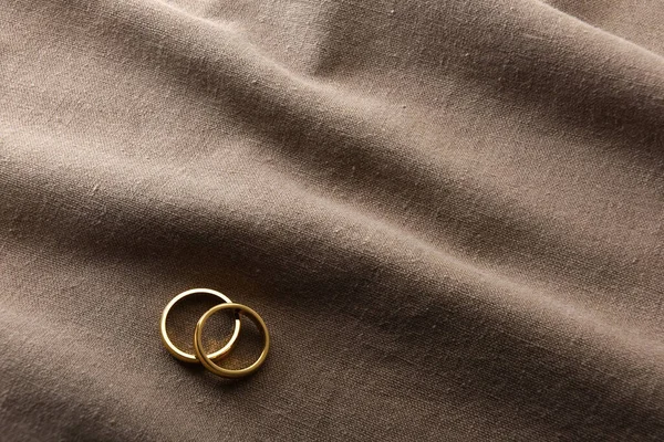 Kahverengi Kumaşta Kırışıklıkları Olan Iki Altın Yüzüğün Ayrıntıları Üst Görünüm — Stok fotoğraf
