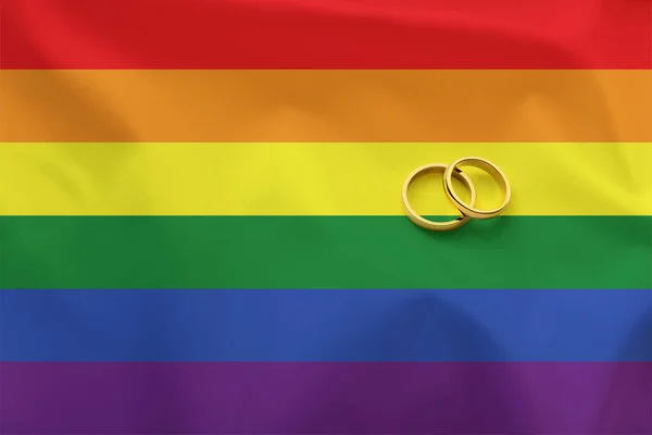 사람들 사이의 결혼에 개념적 사항은 무지개 색깔로 감색된 깃발에 금반지를 — 스톡 사진