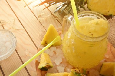 Meyveli taze ananas püresi ve ahşap bir masanın etrafında ezilmiş buz. Manzara yükseldi. Yatay bileşim.