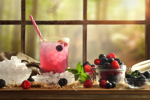 饮料与浆果与水果和冰围绕着它的木制桌子和窗户背景 前面的景色1 横向构成 — 图库照片