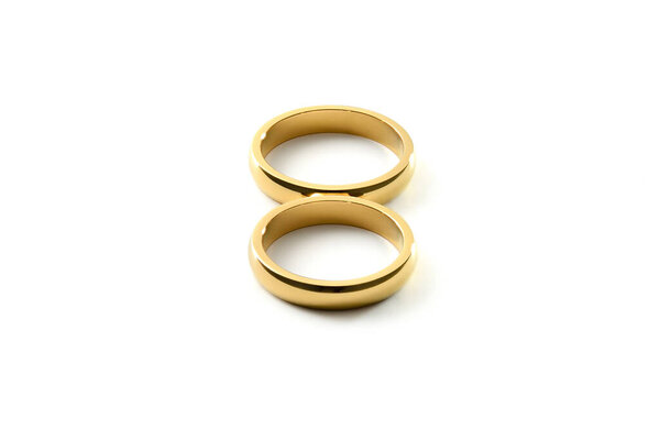 Detail of engagement gold rings forming an eight on white isolated background. Elevated view.