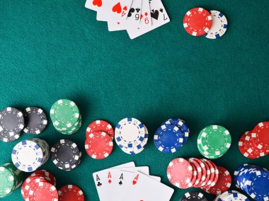 Aslar pokerinde kazanan el ve bir ucunda bir yığın fiş olan masa ve yeşil minderde oyunu olmayan kaybeden. Üst görünüm.