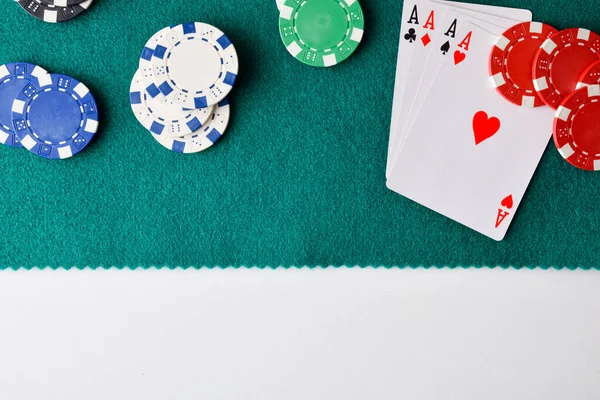 Kağıt hasırı beyaz masada. Bahisler için dört açık as ve fiş var. Üst görünüm.