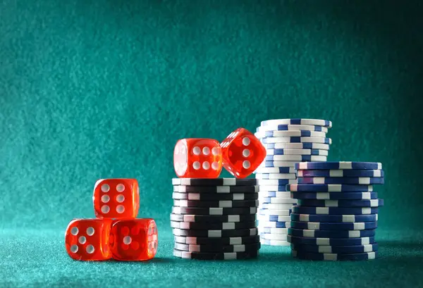 Casino dice game background with pile of betting chips on green felt mat and green isolated mat background. Front view.