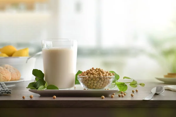 Healthy breakfast with vegetable soy drink in a glass and seeds on a wooden kitchen bench. Front view.