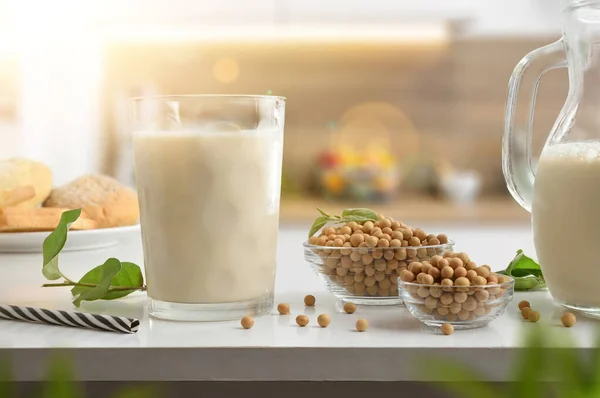 Healthy breakfast with vegetable soy drink in a glass on a kitchen bench with containers full of seeds and bread