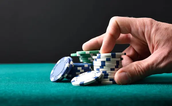 Background with hand betting game chips on green mat and isolated black background. Front view.