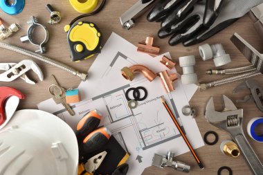 Ahşap masa üzerinde malzeme ve aletlerle ev tesisatının kurulumu ve bakımı. Üst Manzara. Yatay bileşim.