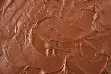 Kahverengi arka plan ve kakao kremi yayılmış doku detayı. Üst görünüm.
