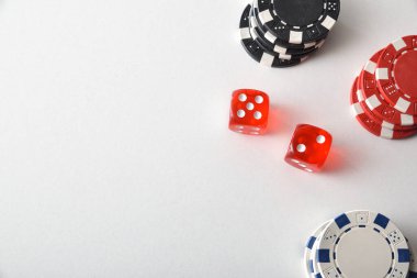 Kumarhane zar oyunu geçmişi, bahis için renkli çipler ve beyaz masada iki kırmızı zarla. Üst görünüm.