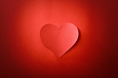 Merkezde kalp kesiği, kırmızı dokulu ve eğimli arka planda izole edilmiş. Üst görünüm.