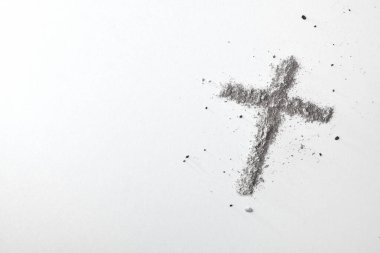 Christian cross made with ashes isolated on white table. Top view. clipart