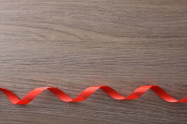 Alttaki dalgalı kırmızı kurdele ahşap masadaki etkinlikler için arka plan dekorasyonu için. Üst görünüm.