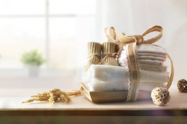 Odadaki ahşap şifoniyerde arka planda pencere olan bebek kıyafetleri ve aksesuarlar. Ön görünüm.