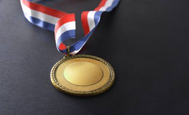 Siyah arka planda mavi beyaz ve kırmızı renkli altın metal madalya. Yüksek görünüm.