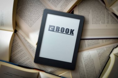Bir yığın açık kağıt üzerinde elektronik kitapla kitap ve geleneksel kağıt kitap arasındaki kapasite kavramı. en üstteki görünüm