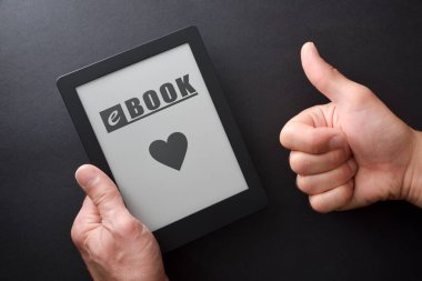 Elinde mesaj ve kalp olan bir kitap olan el yazısı ekranda ve el hareketleriyle siyah masaya izole edilmiş. en üstteki görünüm.