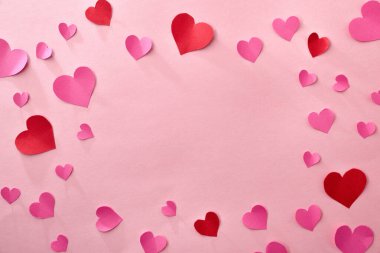 Pembe ve kırmızı kalp kesikli aşk arkaplanı. Pembe arka planda, ortada boşluk var..