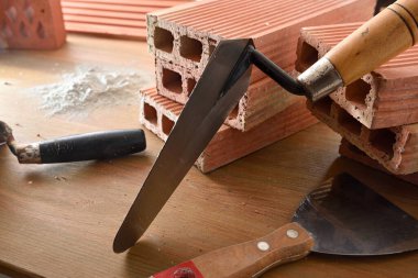 Ahşap tahtada inşaat aletleri, tuğla ve beton tozu olan bir arka plan. Yüksek görünüm.