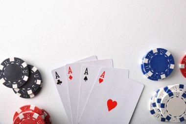 Beyaz masada izole edilmiş bahis için kart ve fiş içeren bir arka plan. Üst görünüm.