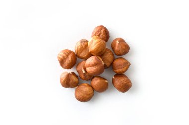 Background detail of heap of shelled hazelnuts isolated on white table. Top view. clipart