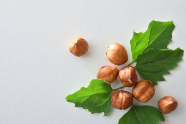 Group of shelled hazelnuts and leaves isolated on white background. Top view. clipart