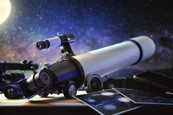 White telescope on wooden table with tools pointing at a starry sky at night. Rear view.