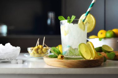 Mutfak tezgahında limonlu, limonlu, nane şekerli, buzlu, abur cuburlu ve arka planda karanlık mutfağı olan mutfak tezgahı. Ön görünüm.