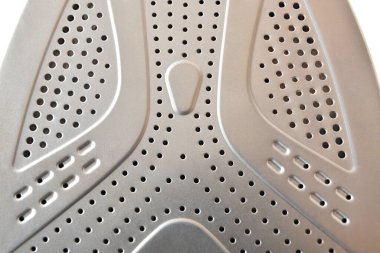 Evin ütülenmesi için simetrik buhar delikleri olan metal taban levhası ayrıntıları, beyaz üzerine izole edilmiş.