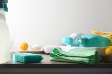 Beyaz izole edilmiş arka planı olan ahşap bir masa üzerindeki dezenfektan ürünleri, paçavralar ve acourer gibi çeşitli temizlik ürünleri. Ön görünüm.