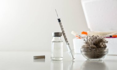 Toz maytı alerjisi tedavi konsepti. İçinde ilaç şişeleri, şırıngalar ve bir kase dolusu toz olan beyaz bir masanın üzerindeki kaplar. Ön görünüm.