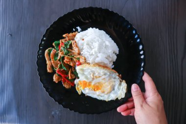 stir fried pork with chili, holy basil and rice with sunny side up egg for serve