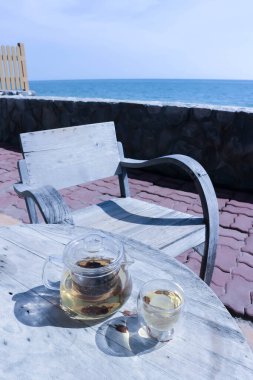 tea and teapot near the beach , sea and sky background