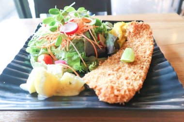 Domates soslu kızarmış balık ve salata ya da soslu balık ve patates kızartması.